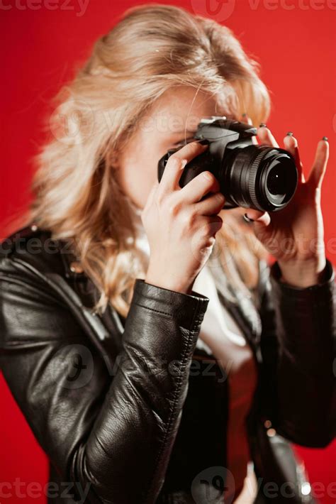 Portrait of a beautiful girl photographer with a camera in her hands ...