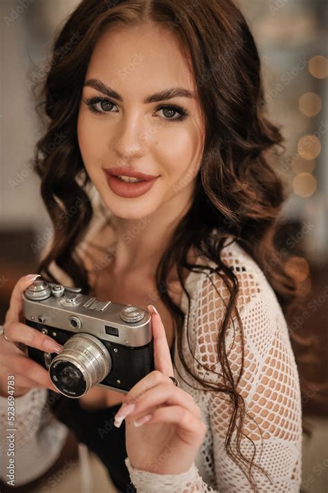 beautiful sexy brunette with a beautiful figure in sexy lingerie with a vintage camera Stock ...
