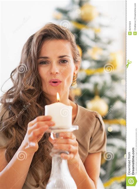 Young Woman Blowing Candle in Front of Christmas Tree Stock Photo - Image of female, luxury ...