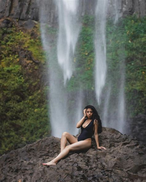 Photo of Woman in Black Swimsuit Posing on Rock with Waterfall in the ...