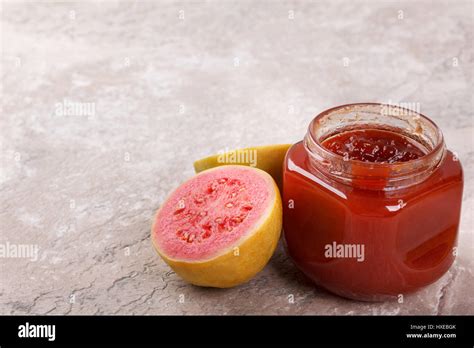 Brazilian dessert goiabada - jam of guava with fresh goiaba on gray background. Selective focus ...