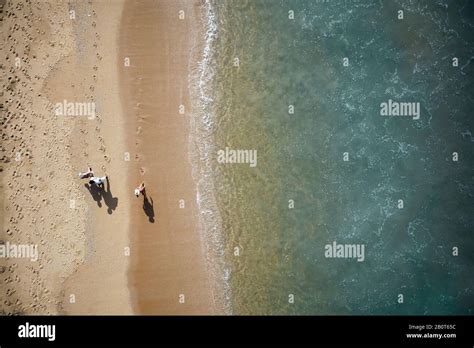 People walking along the beach. Aerial View of Waves and Azure beach ...