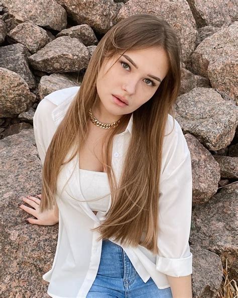 a young woman posing in front of some rocks