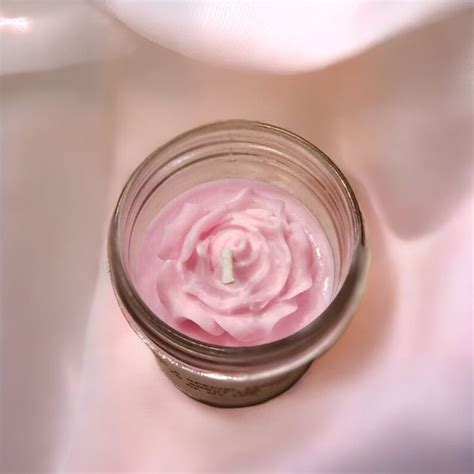 a jar filled with pink whipped cream sitting on top of a white cloth