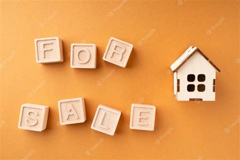 Premium Photo | The inscription house for sale made of wooden cubes on an orange background the ...