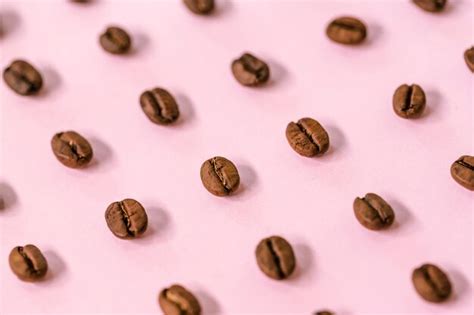 Premium Photo | Medium roast arabica coffee beans on pink background