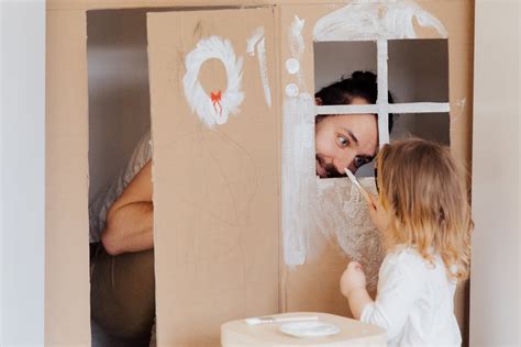 A Little Girl and her Dad Painting a Cardboard House · Free Stock Photo