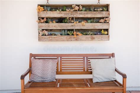 Vertical Wooden Planters with Succulents on White Wall with Backyard Bench and Pillows Stock ...