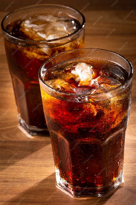 Premium Photo | Cola soda glass with ice cubes on wooden table