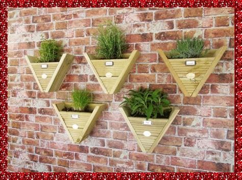 three wooden planters mounted to a brick wall with plants growing in them on the sides