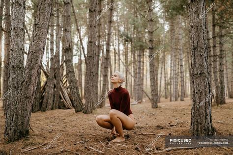 Beautiful modern woman resting barefoot in evergreen forest — person ...