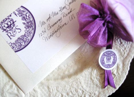 a close up of a purple ribbon on a white plate with an envelope and seal