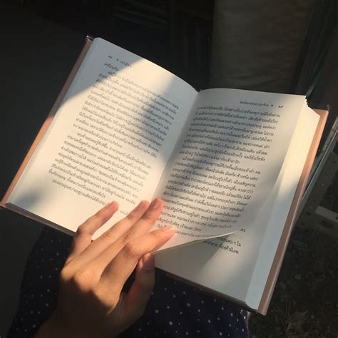 a person is holding an open book in their left hand and the sun shining on them