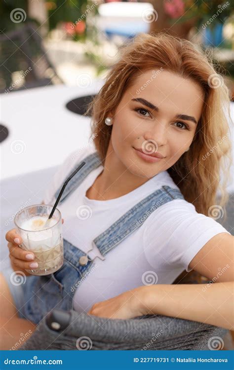 White Blonde Woman Holding A Glass Of Coffee Latte In Her Hand. Royalty-Free Stock Photo ...