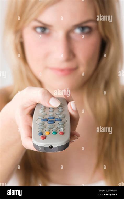 Blonde woman using remote control, portrait Stock Photo - Alamy