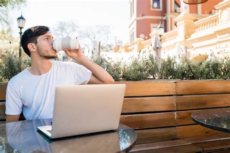 Premium Photo | Young man using his laptop in a coffee shop.