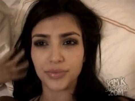 a close up of a person laying in a bed with a white sheet and pillows