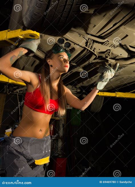 Beautiful Young Female Mechanic Inspecting Car In Auto Repair Shop ...