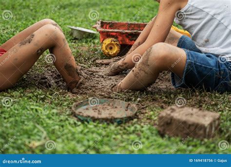 Boys playing with mud stock photo. Image of delight - 169418756