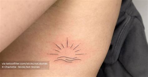 Minimalist hand poked sun and wave tattoo on the rib.