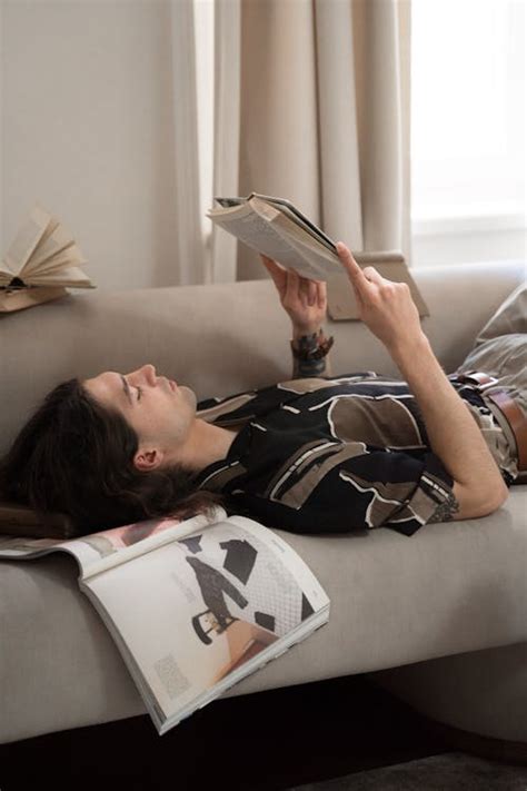 A Man Reading Book while Sitting on a Bed · Free Stock Photo