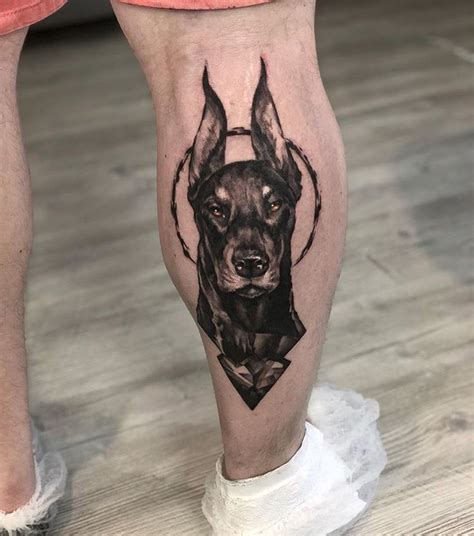 a man's leg with a dog tattoo on it, and his legs are covered in black ink