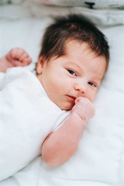 Cute Little Newborn Baby with Short Dark Hair in White Bodysuit Look ...