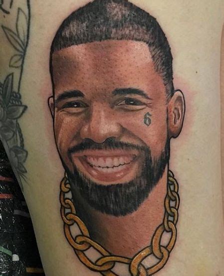 a close up of a person with a tattoo on his leg and a chain around his neck