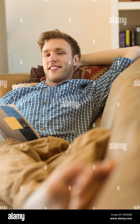 Young man reading on his couch Stock Photo - Alamy