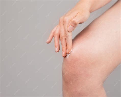 Premium Photo | Woman applying ointment on knee for pain and swelling