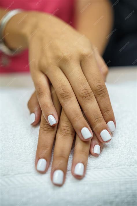 Premium Photo | Woman applying nail polish to toenails in spa center