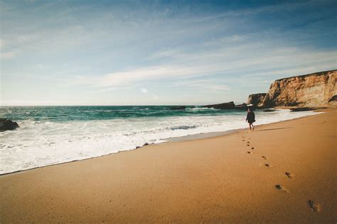 lone woman enjoys walk on the beach in idyllic paradise view, woman in