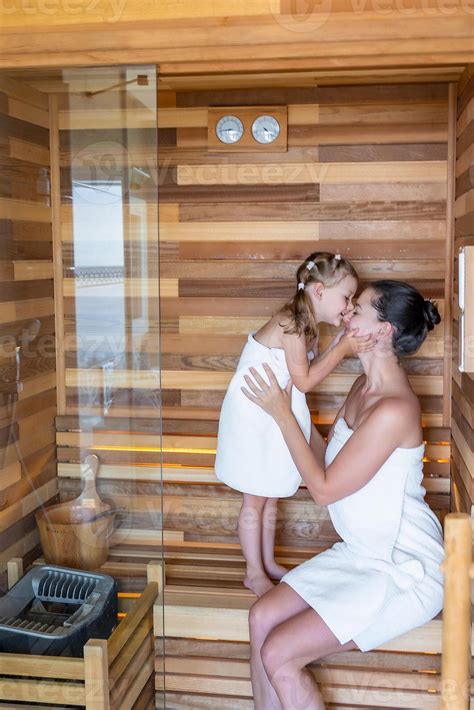 Mom and daughter in sauna enjoying time together. Girly pastime concept
