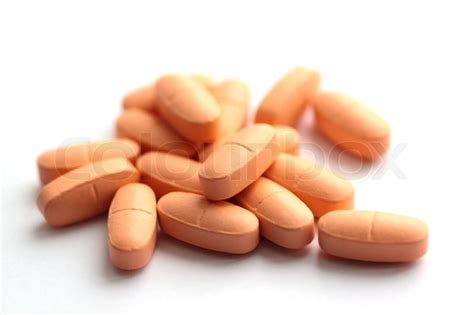 Group of light orange pills on a white background | Stock Photo | Colourbox