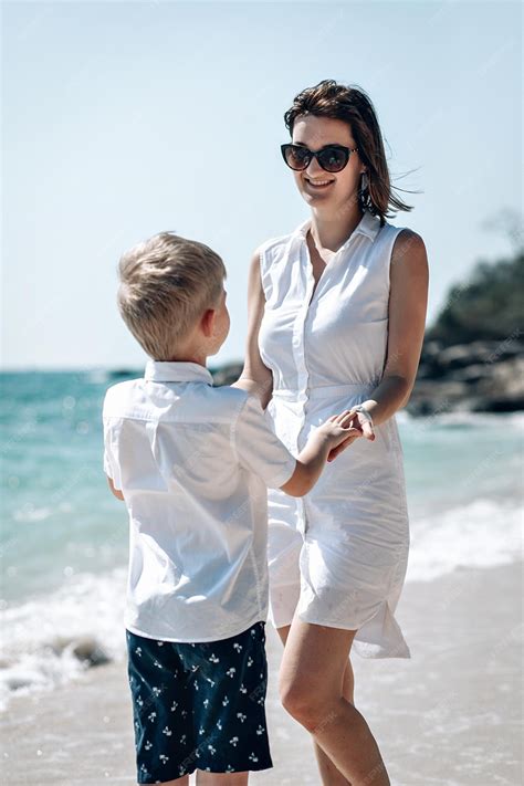 Premium Photo | Mother and son watch the sea together. mom holds hand