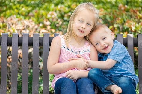 Young Sister and Brother Having Fun On The Bench At The Park 16360581