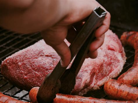 Someone grills meat and sausages on a bbq. photo – Free Food Image on