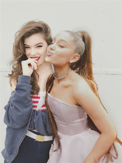 two young women are kissing each other in front of a white wall
