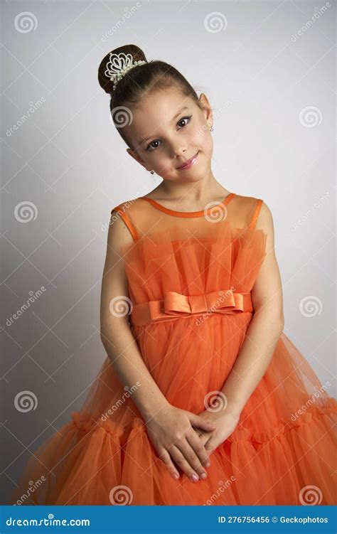 Cute Little Girl in Orange Dress Posing Over White Background Stock ...