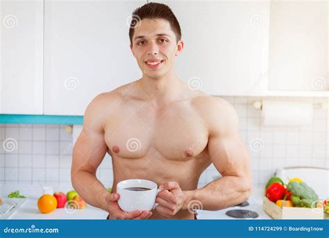 Bodybuilder Young Man Shirtless Drinking Coffee in the Kitchen M Stock ...