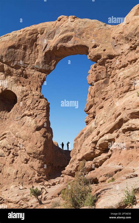 Silhouettes under the Turret Arch in Arches National Park, Utah, USA ...