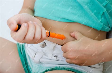 Premium Photo | Child injects himself with insulin in the abdomen at home