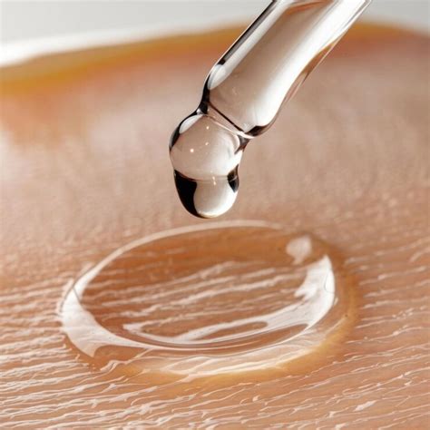 closeup shot   clear serum drop falling   applicator