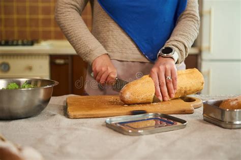 cropped view   woman housewife   blue hijab cutting loaf