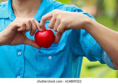 businessman pulling  red heart pocket stock photo