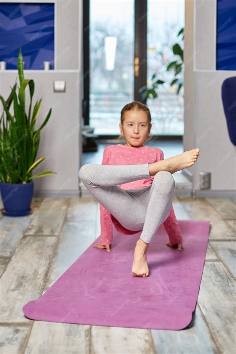 Premium Photo | Little girl doing stretching exercises, practicing yoga