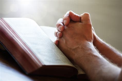 Praying hands on a Holy Bible – The Connecting Church