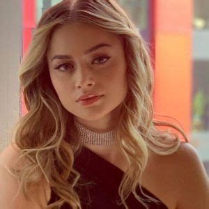 a woman with long blonde hair wearing a choker and black dress looking ...