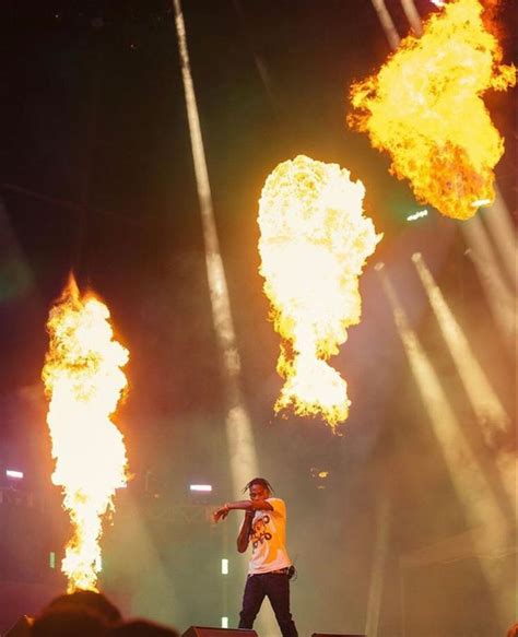 a man standing on top of a stage surrounded by bright yellow and red ...