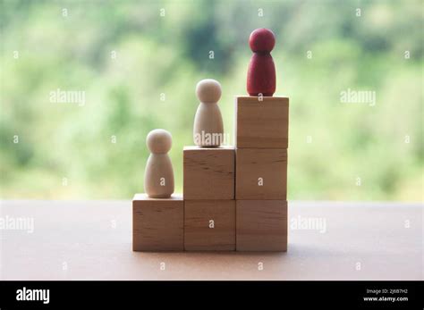 Wooden dolls standing on stack of wooden blocks. Business concept of ...